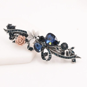 Détail d'une pince à cheveux vintage avec cristaux bleu foncé et roses roses