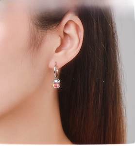 Close-up of S925 silver hoop earrings with a vibrant oval-cut rainbow zircon pendant