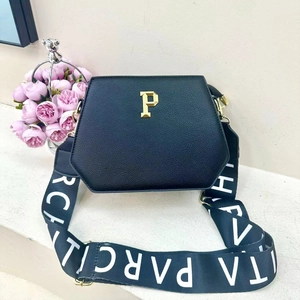 Chic black hexagonal tote bag with golden P logo and wide branded fabric shoulder strap