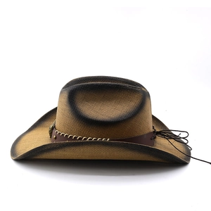 Detail of western cowboy straw hat with gradient edges and brown leather band decoration