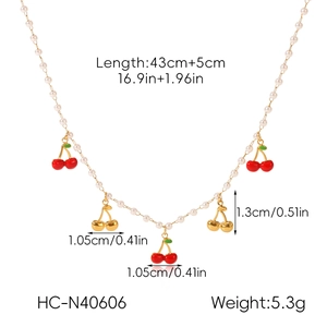 Vue détaillée du collier cerise doré avec pendentif rouge 1,3 cm et perles blanches