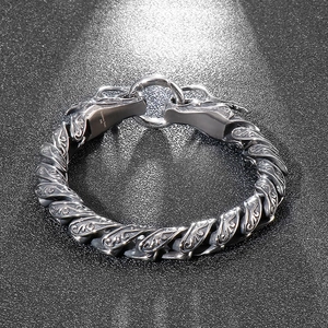Detailed macro of 316L stainless steel bracelet featuring dual dragon heads and textures