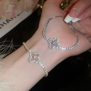 Gros plan du bracelet trèfle rose serti de diamants étincelants en or et argent
