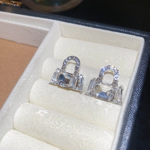 Macro shot of sparkling handbag-shaped earrings with large crystals in a soft jewelry box