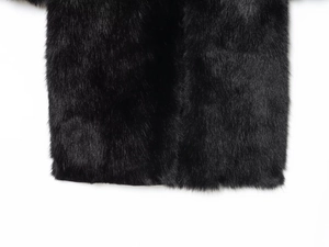 Detailed macro view showing the texture and hem of black faux fur long winter coat