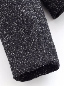 Macro shot of black and white tweed fabric texture on a stylish fashion suit