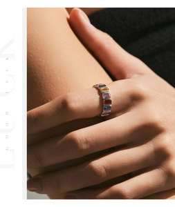 Close-up of s925 silver eternity ring with baguette-cut rainbow stones on finger