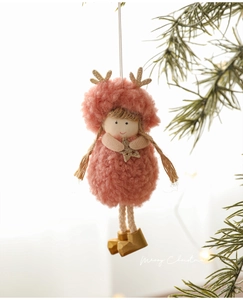 Detailed close-up of a plush angel doll with gold antlers on a Christmas tree