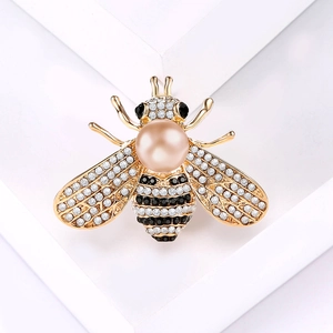 Detailed view of bee brooch with champagne pearl body and sparkling crystals