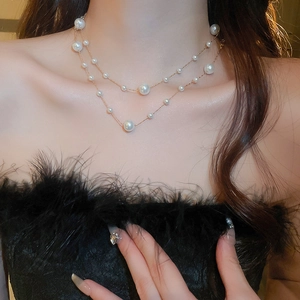 Close-up of double-layer gold plated necklace with pearls on model with soft lighting
