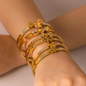 Layered 18K gold plated stainless steel bow cuff bracelets with elegant pearl accents