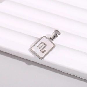 Macro shot of silver square zodiac pendant featuring Scorpio symbol on white inlay
