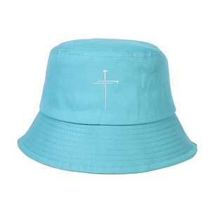 Gros plan d'un bob en coton bleu clair avec broderie croix blanche et bord surpiqué