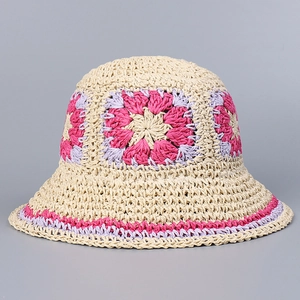 Close-up of hand-crocheted straw hat with pink and purple floral knit patterns