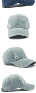 Detail of washed denim baseball cap with distressed rip texture and adjustable metal buckle