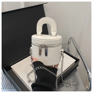 Vue détaillée de la vanity case cylindrique blanche avec chaîne en argent et poignée