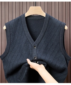 Detailansicht der dunkelblauen Strickweste mit V-Ausschnitt, schwarzen Knöpfen und Textur