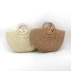 Detail showing two woven straw tote bags in beige and brown with round handles