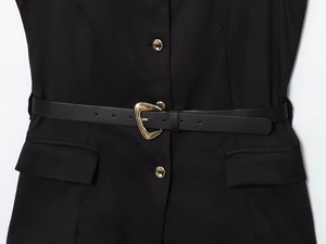 Detail view of black sleeveless vest with a slim leather belt and gold heart buckle