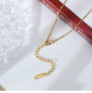 Detail view of the elegant golden necklace lobster clasp and adjustable extension chain link