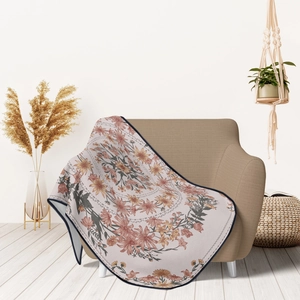 Detail of soft flannel blanket with floral mandala pattern draped on a cozy sofa chair