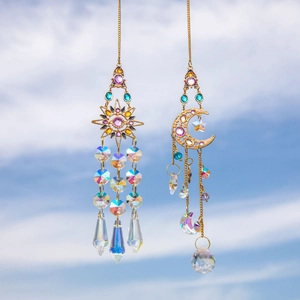 Golden sun and moon crystal suncatchers with faceted beads hanging against a blue sky