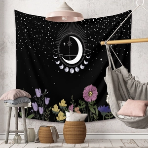 Bohemian moon phase tapestry with floral accents hanging in a modern living room