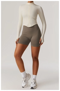Détail de la veste crème avec passe-pouces et short de yoga taupe sans couture