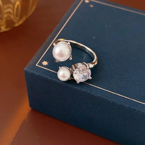 Détail de perles irrégulières et pierres de zircon sur une bague argentée réglable