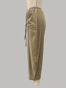 Detail van de kaki corduroy broek met verticale ribstructuur en elastische tailleband