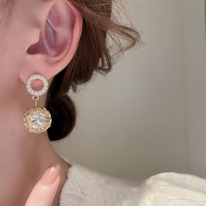 Close-up of elegant gold openwork drop earrings with pearls on model, luxury style