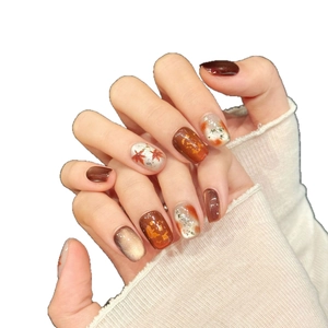 Handmade autumn press-on nails featuring maple leaf art, cat eye effect and caramel tones