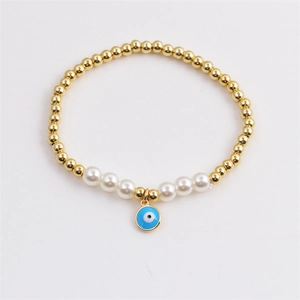 Bracelet œil de protection avec perles dorées et perles blanches sur fond blanc