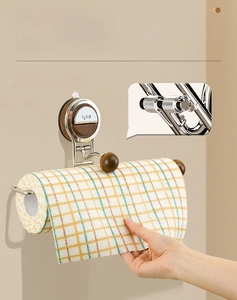 Detail of wall-mounted paper towel holder with spring arm and wooden finish