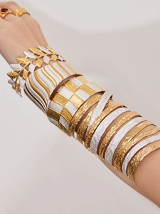 Detailansicht geschichteter Gold- und Silberblatt-Armbänder mit gemischten Texturen