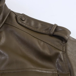 Détail d'une veste en similicuir marron foncé avec épaulettes et coutures de précision