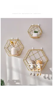 Close-up of golden hexagonal floating wall shelves with wooden base for home decor