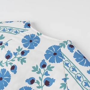 Gros plan du motif floral bleu sur le manteau en coton montrant les détails