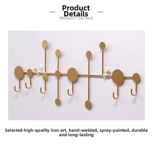 Close-up of golden iron wall hook rack featuring modern circular art and J-shaped hooks