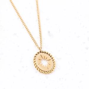 Close-up of golden oval pendant with star cutout and twisted rope texture on cable chain