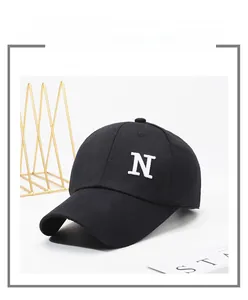 Detailed view of white embroidered letter N on a black cotton baseball cap fabric