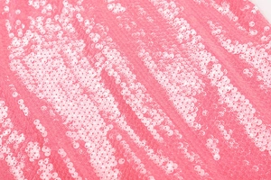 Macro shot of wavy sequins on pink mesh fabric for evening dress detailing