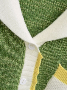 Detail of green knit cardigan with white collar and stitching textures on the fabric
