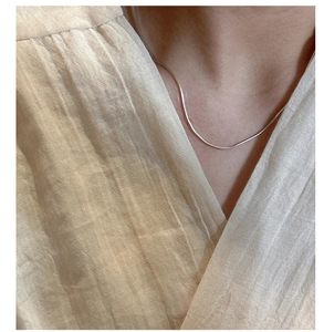 Dettaglio di una collana minimalista in argento S925 a catena di serpente al collo