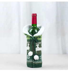 Detail of Christmas wine bottle cover with green knit reindeer pattern and white faux fur