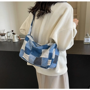 Détail du sac bandoulière en patchwork de denim bleu avec coutures contrastées et style rétro