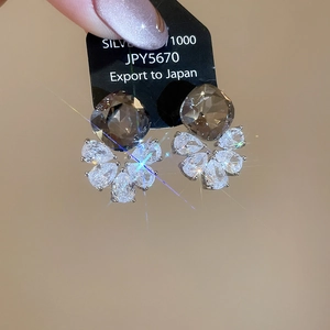 Macro shot of 1000 sterling silver earring with drop-cut zircon and smoky gemstone
