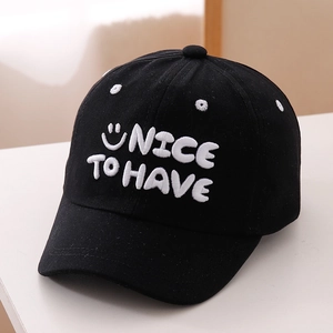 Close-up of white 3D embroidery showing NICE TO HAVE and smiley face on black baseball cap