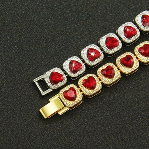 Detail of silver and gold Cuban bracelets featuring red heart stones and crystal pavé