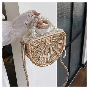 Detail of semi-circular woven bamboo bag with large pearl handle and canvas drawstring